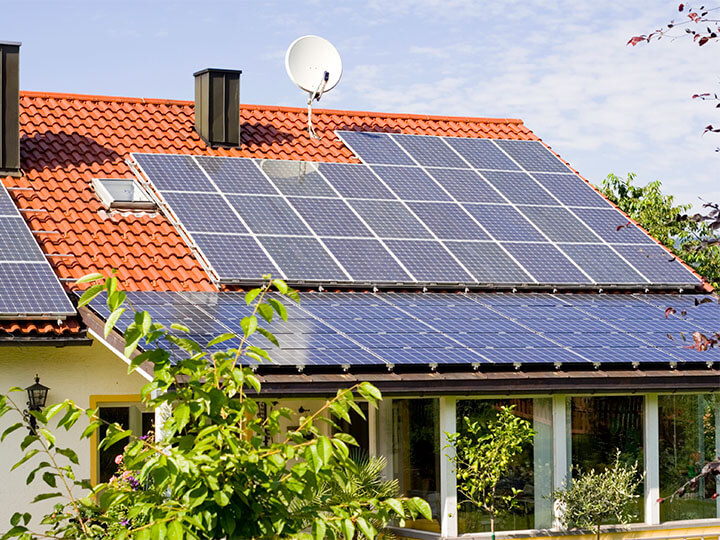 Solar panels on top of a residential house with clay roof shingles