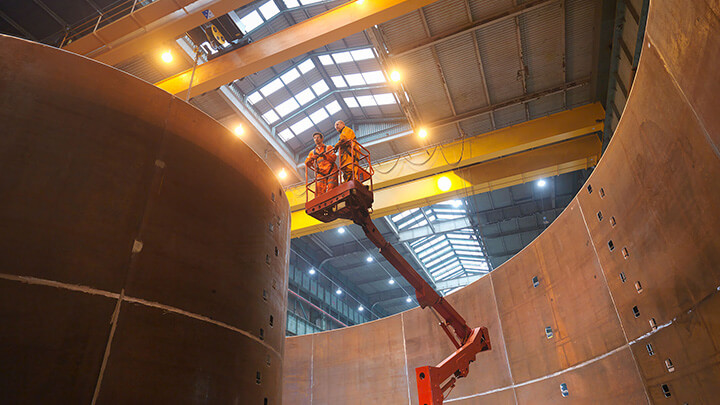 Industrial workers on lift equipment